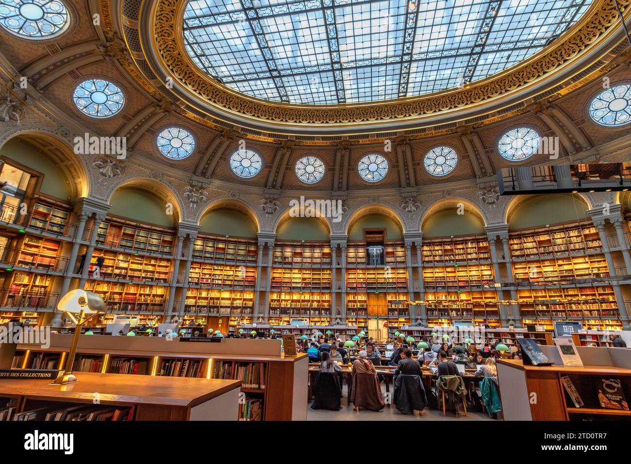 People reading and studying the books at The magnificent Oval reading room at Bibliotheque Nationale de France (BNF), Richelieu Site, Paris,France Stock Photo