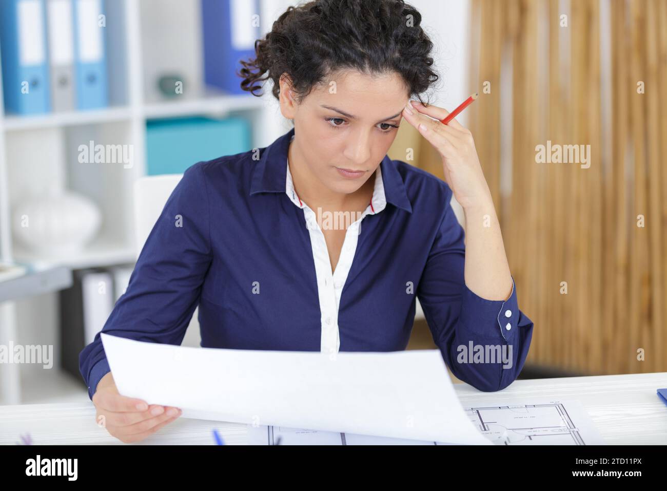 young woman architect constructor analyzing blueprint in office Stock Photo