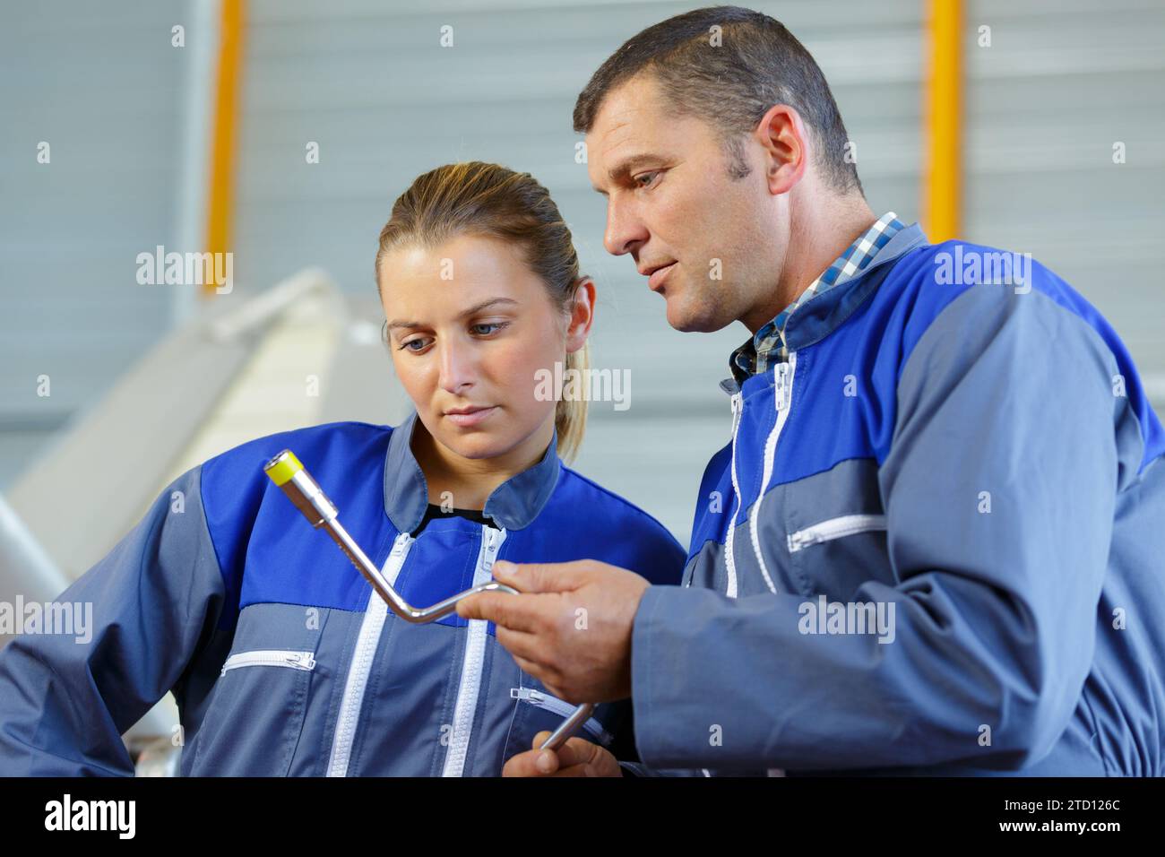 team of technicians looking at mechanical object Stock Photo