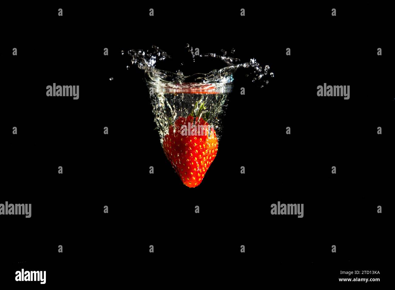 Erdbeere die ins Wasser fällt mit Tropfen Stock Photo