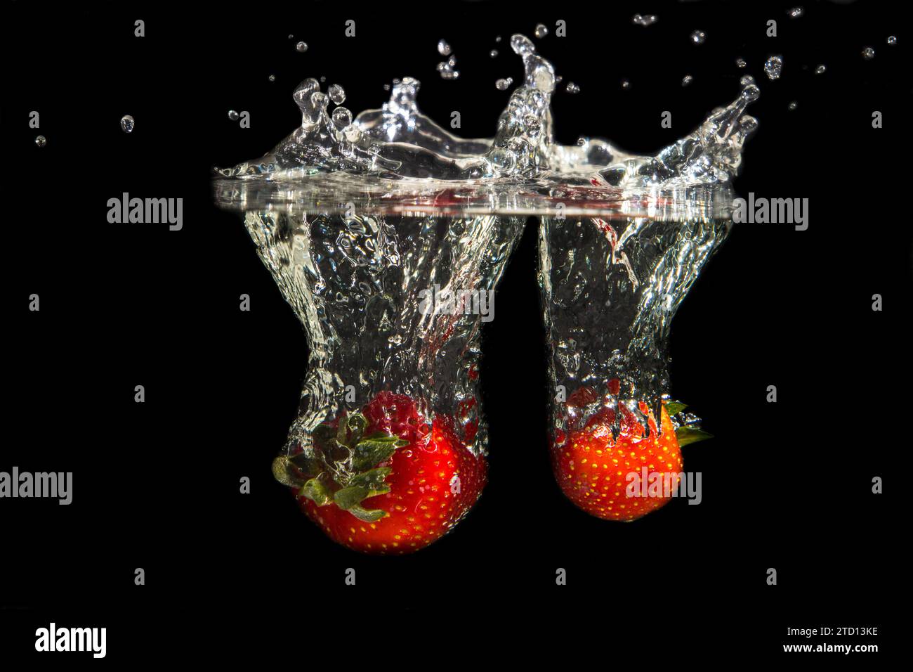Erdbeere die ins Wasser fällt mit Tropfen Stock Photo