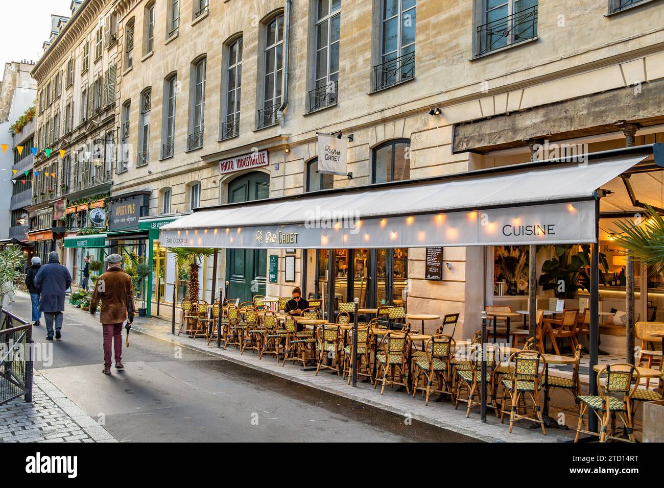 A woman sitting on the outdoor terrace at  Le Petit Cadet a bistro on Rue Cadet in the 9th arrondissement , Paris,France Stock Photo