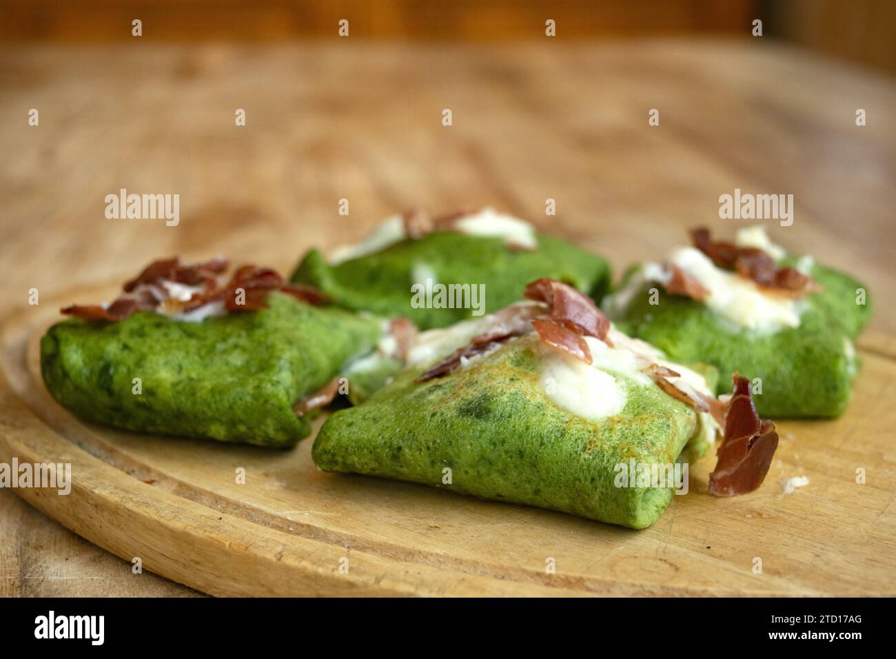 spinach crepes with roasted speck and parmesan cream Stock Photo