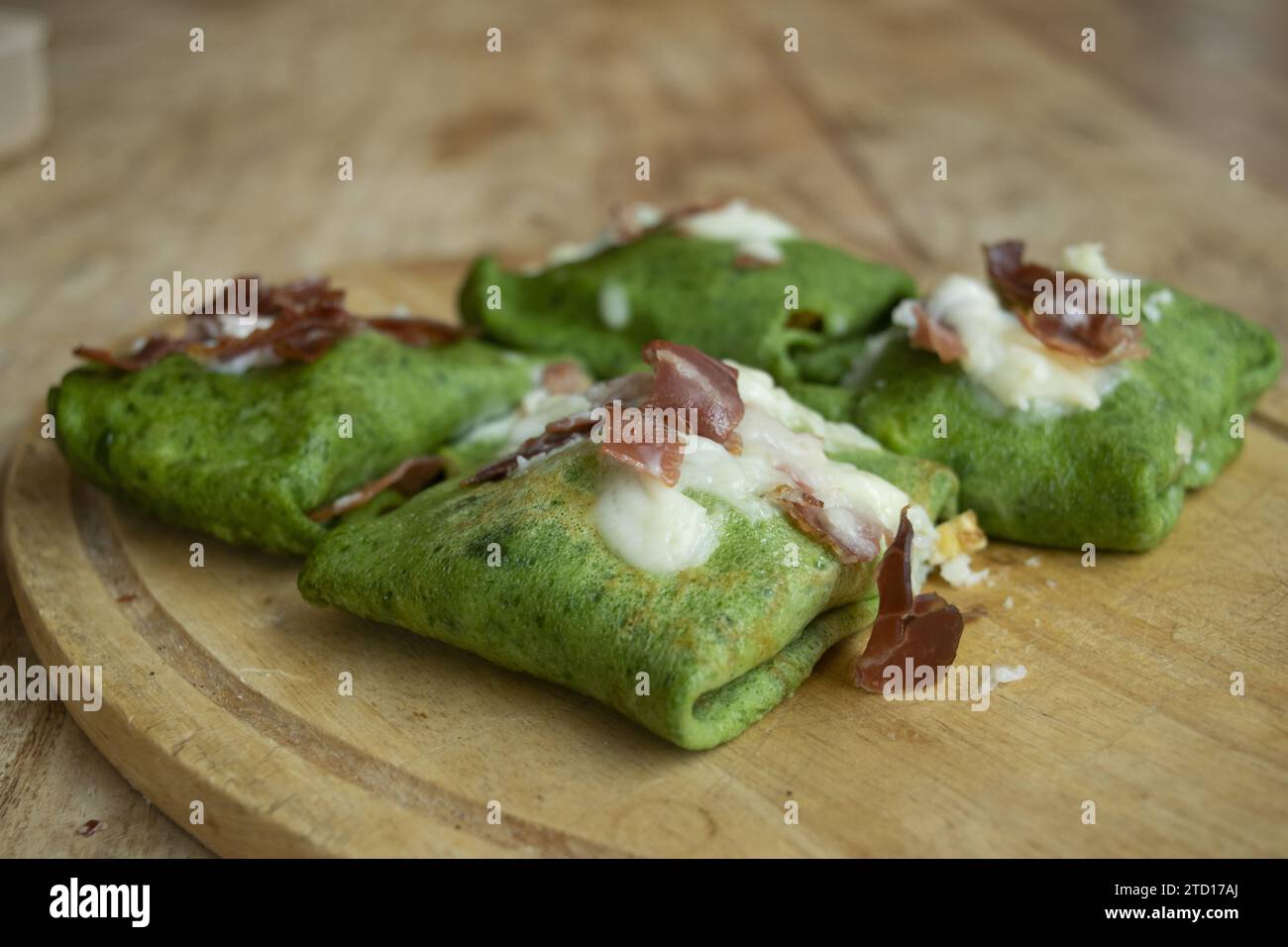 spinach crepes with roasted speck and parmesan cream Stock Photo