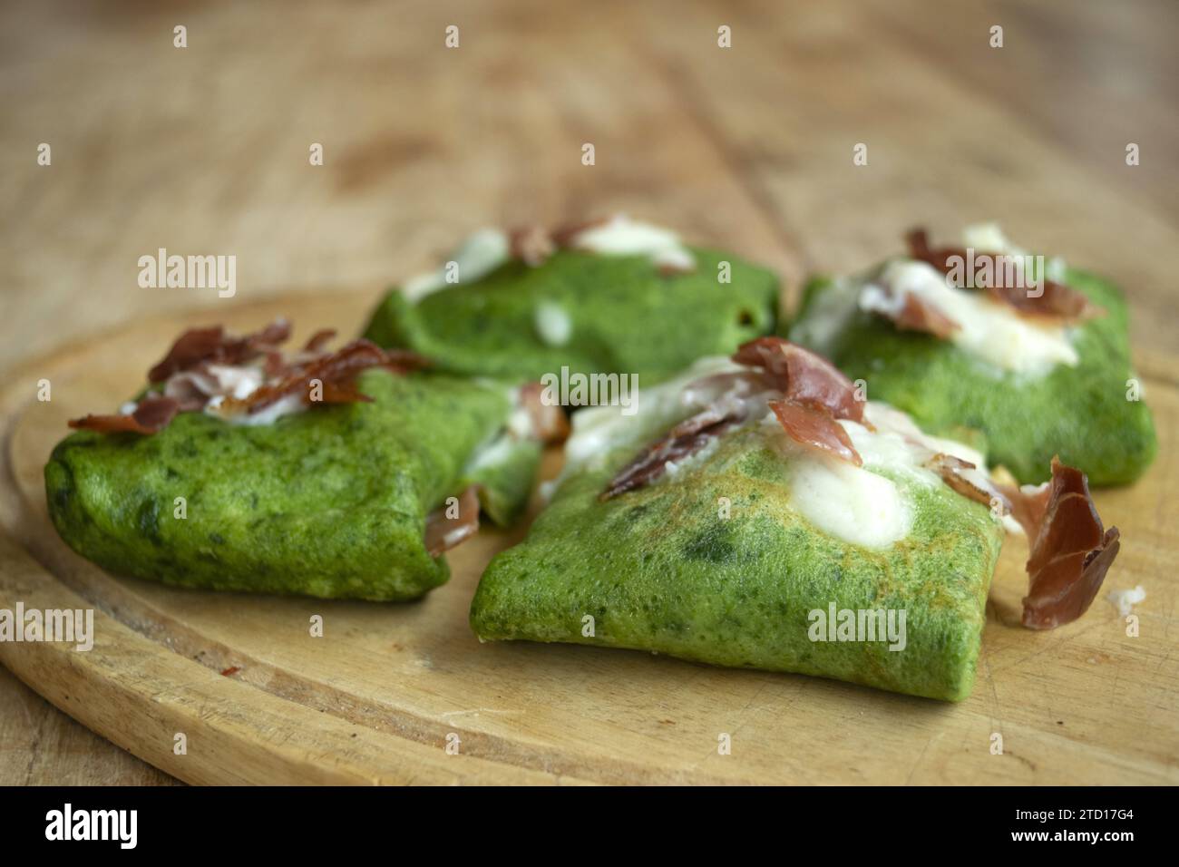 spinach crepes with roasted speck and parmesan cream Stock Photo