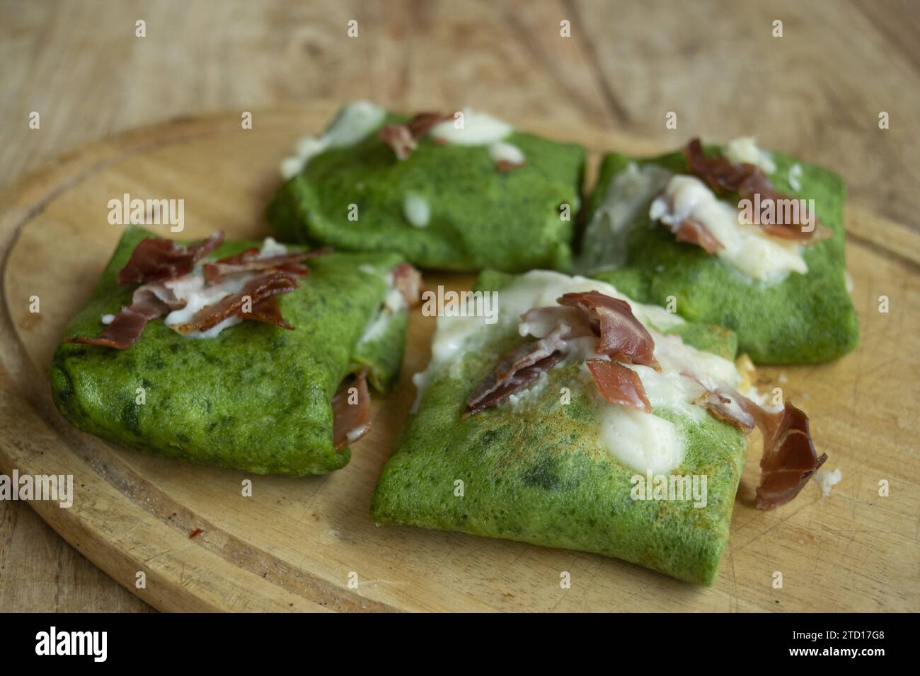 spinach crepes with roasted speck and parmesan cream Stock Photo