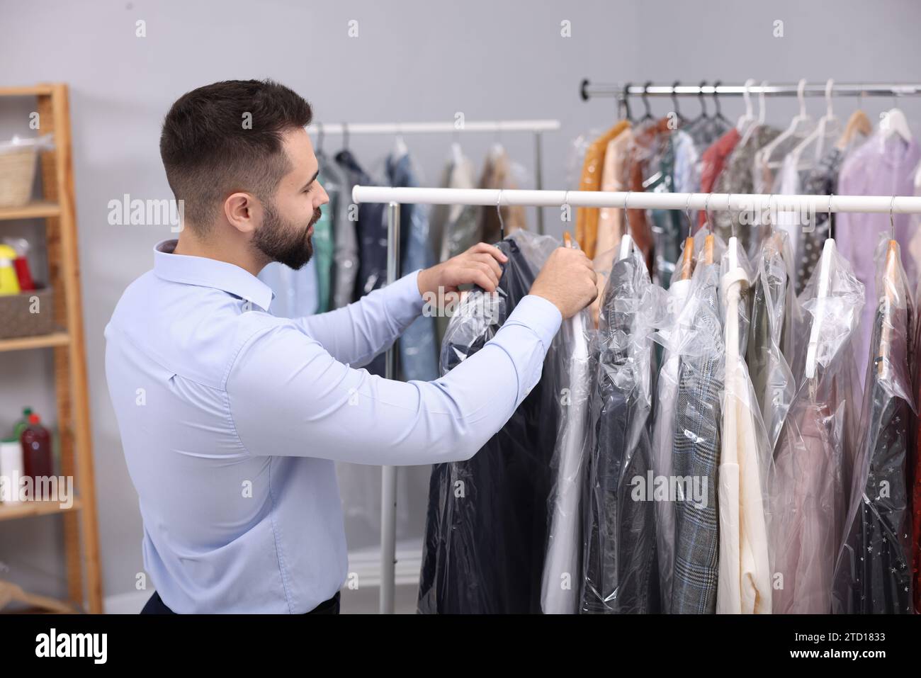 Concept of dry cleaning service. Hangers with clean clothes hanging on rack  Stock Photo - Alamy