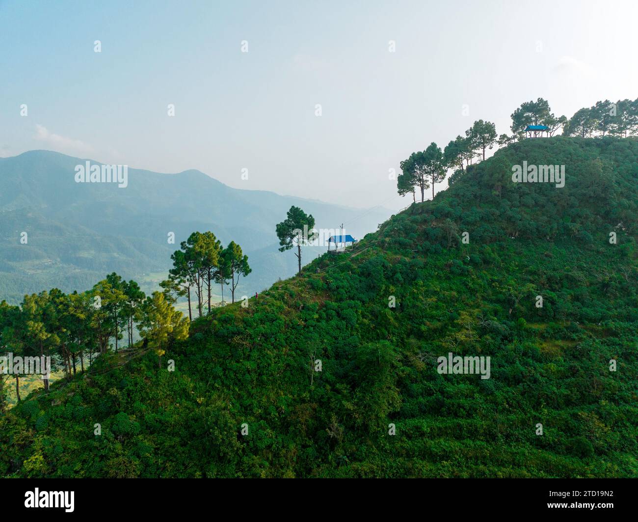 Aerial view of the hill of Thani mai temple, close to Bandipur, Nepal. View of the hill in backlight with the silhouettes of trees and temples Stock Photo