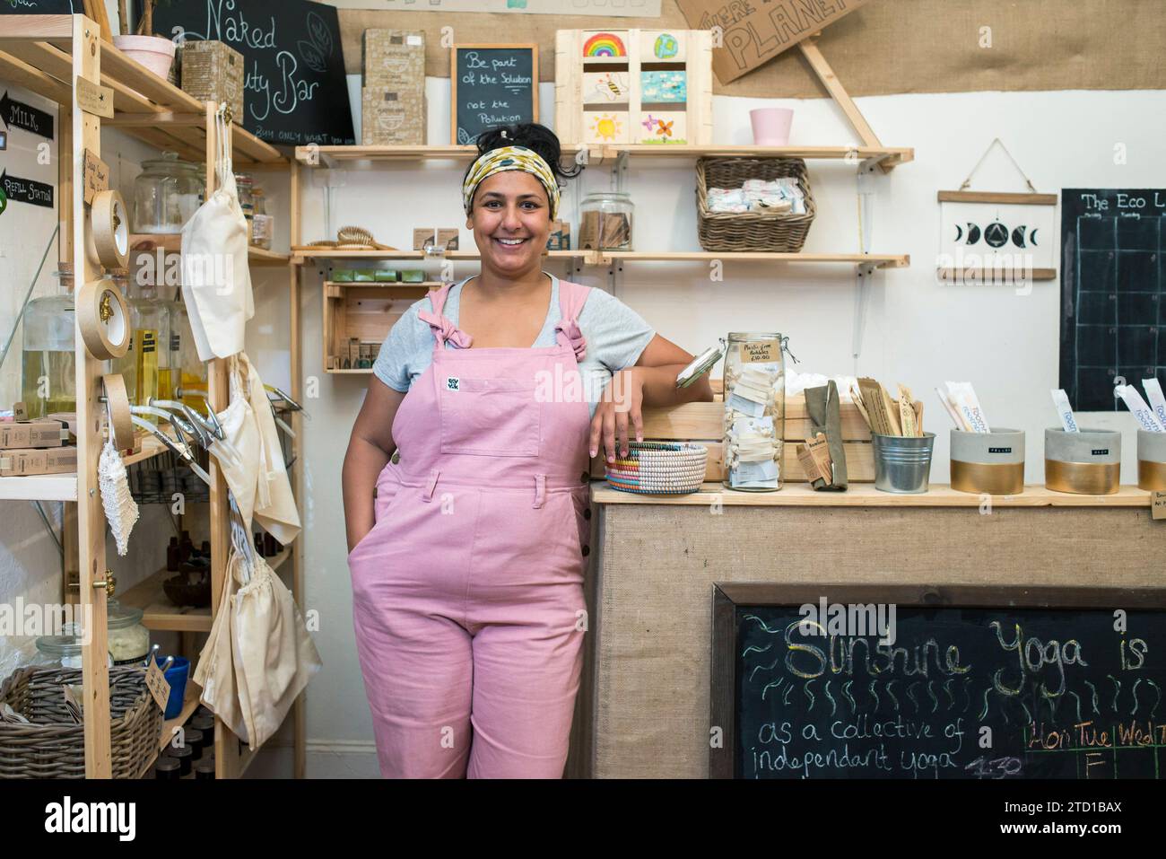 A young woman and business owner stands in her environmentally friendly natural food and drink shop. Stock Photo