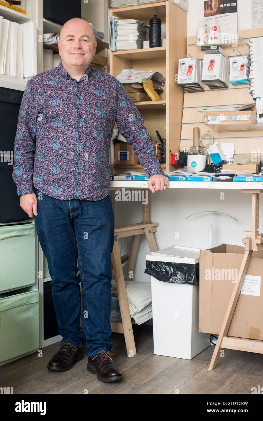 A small business owner and technology manufacturer poses for a portrait at their work station in their industrial unit. Stock Photo