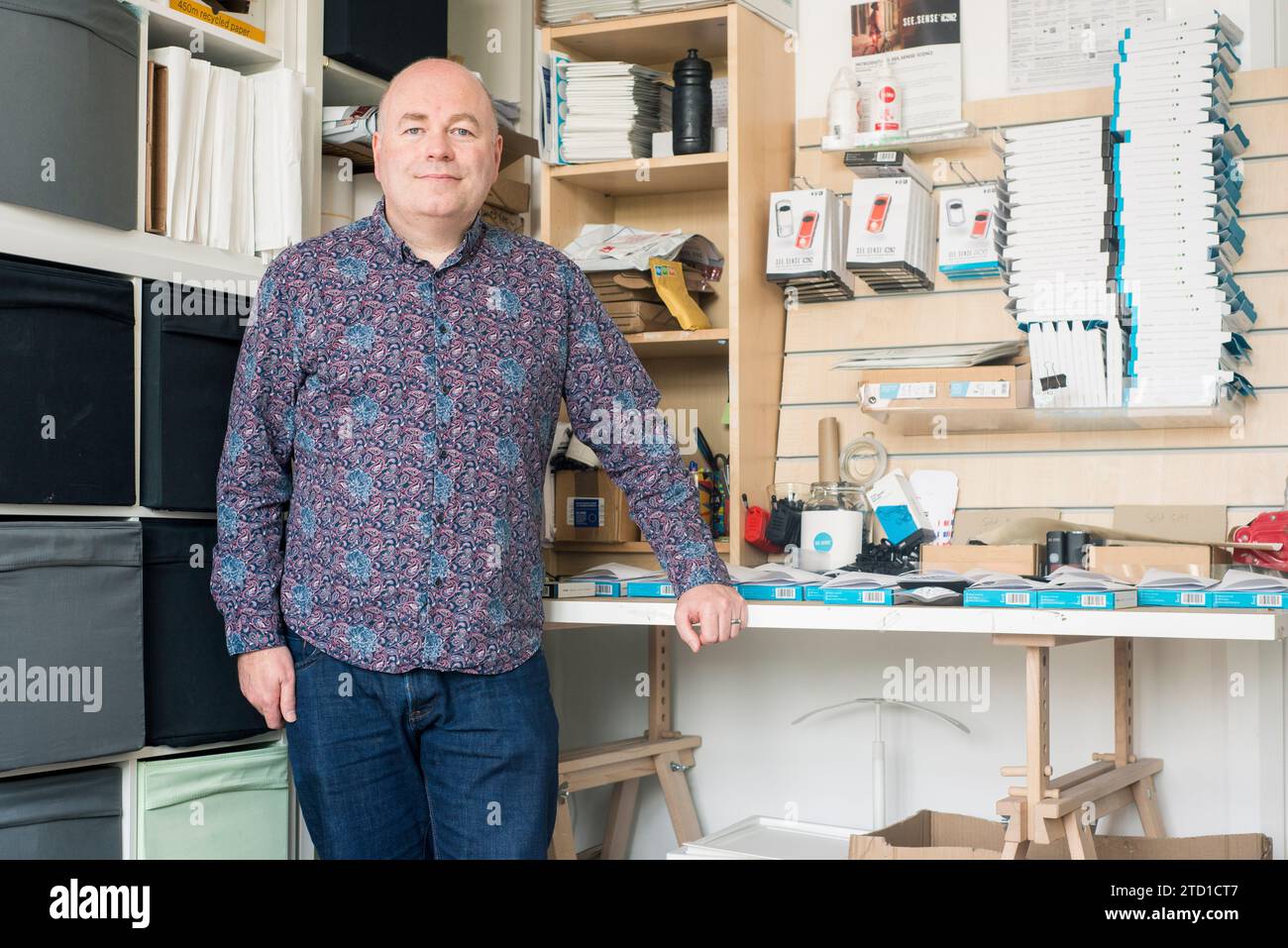 A small business owner and technology manufacturer poses for a portrait at their work station in their industrial unit. Stock Photo