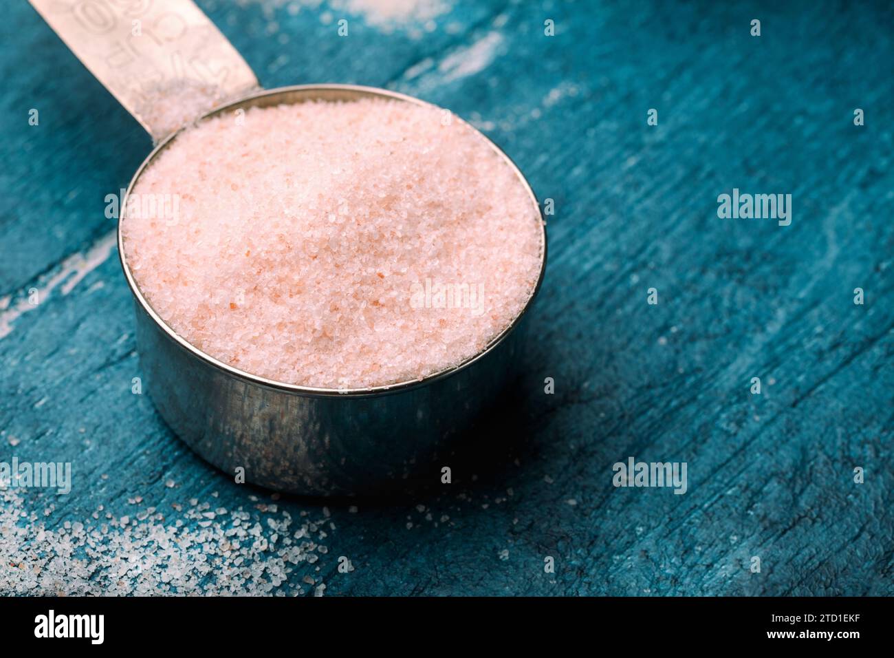 Pink Himalayan salt in measuring spoon on wooden background. Stock Photo