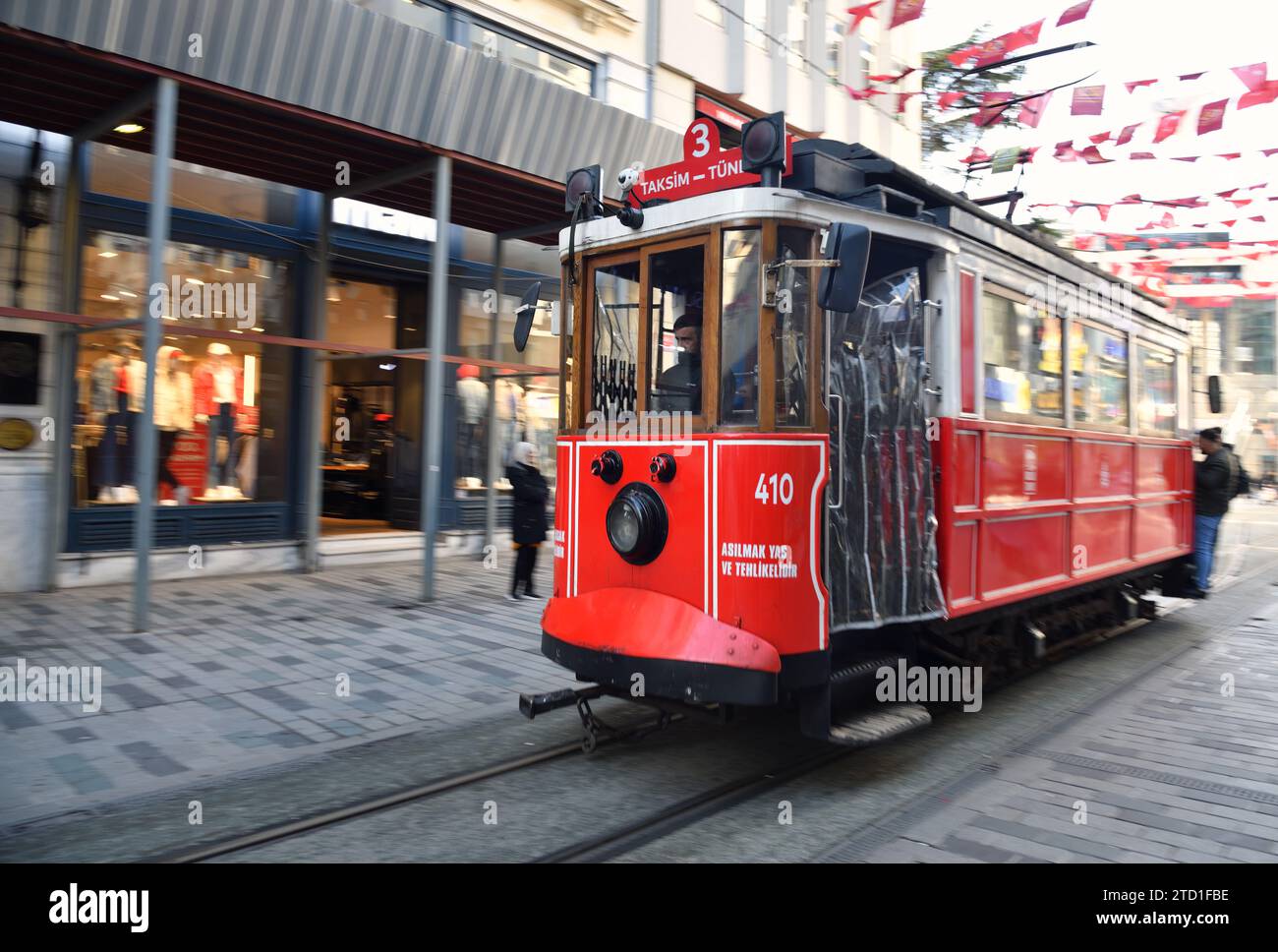 Istanbul, Turkey - December 10, 2023:  Historic red tram carrying people on Istiklal Avenue. Red tram is one of the symbol of Istanbul trams started t Stock Photo