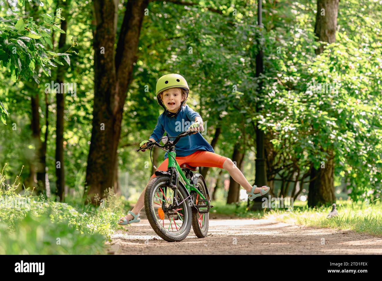 A child learning to ride a bicycle is unable to maintain balance and falls down. Stock Photo