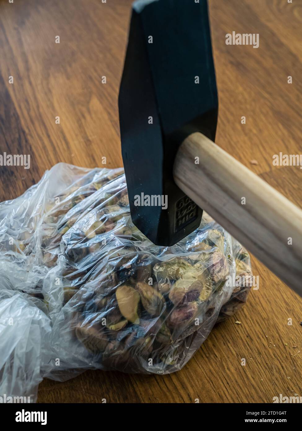 Crushing pistachios into powder breaking down with a hammer in a