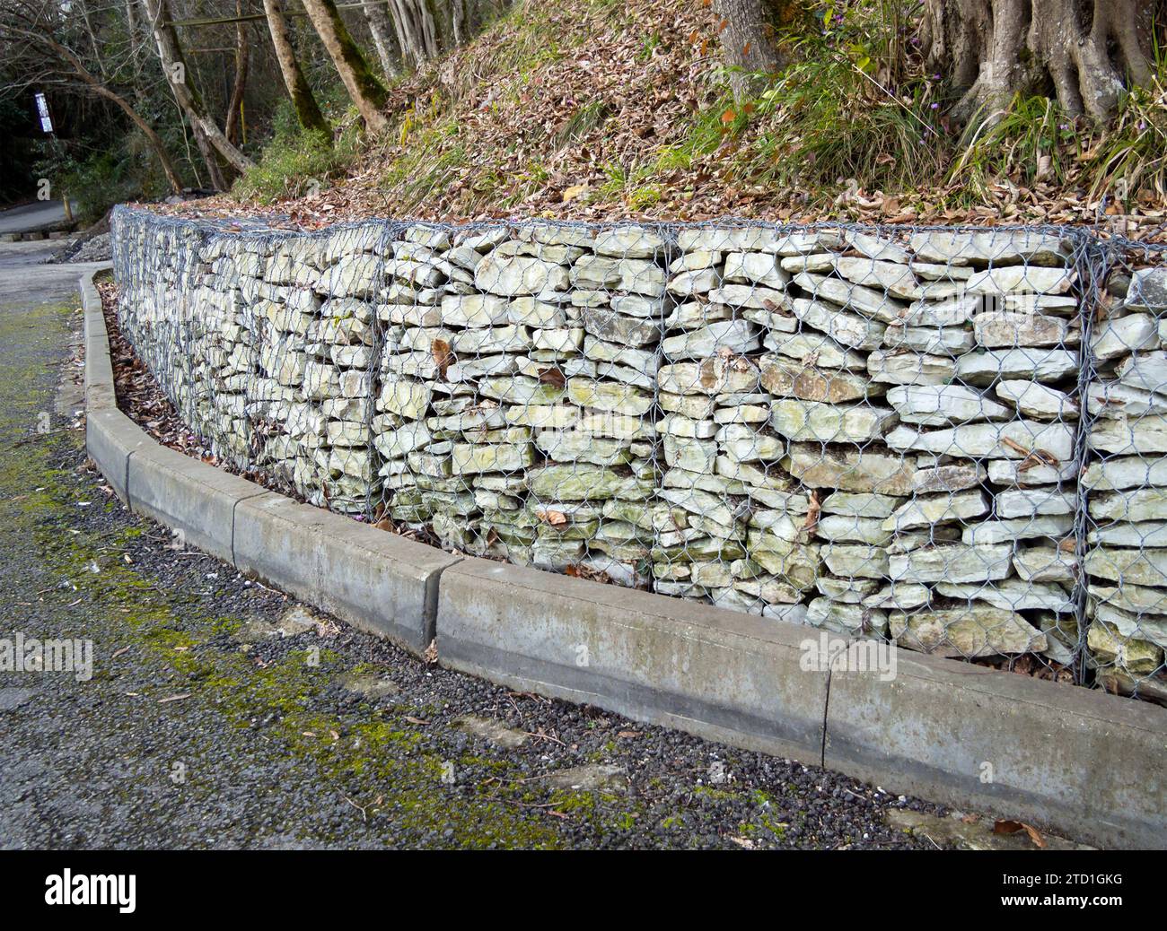 The edge of the roadway with a gabion retaining wall Stock Photo