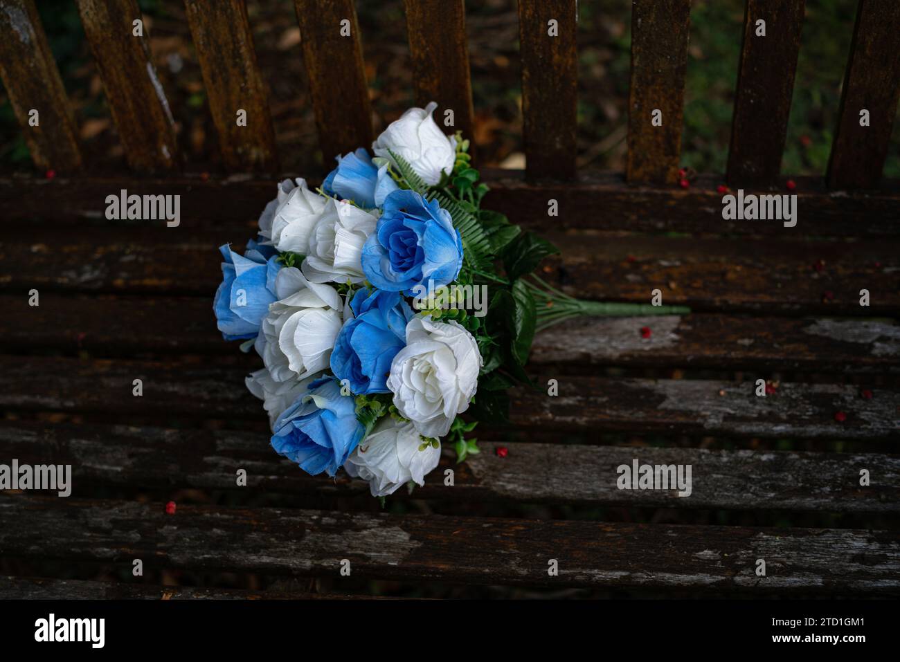 Silk flowers abandoned on a bench Stock Photo