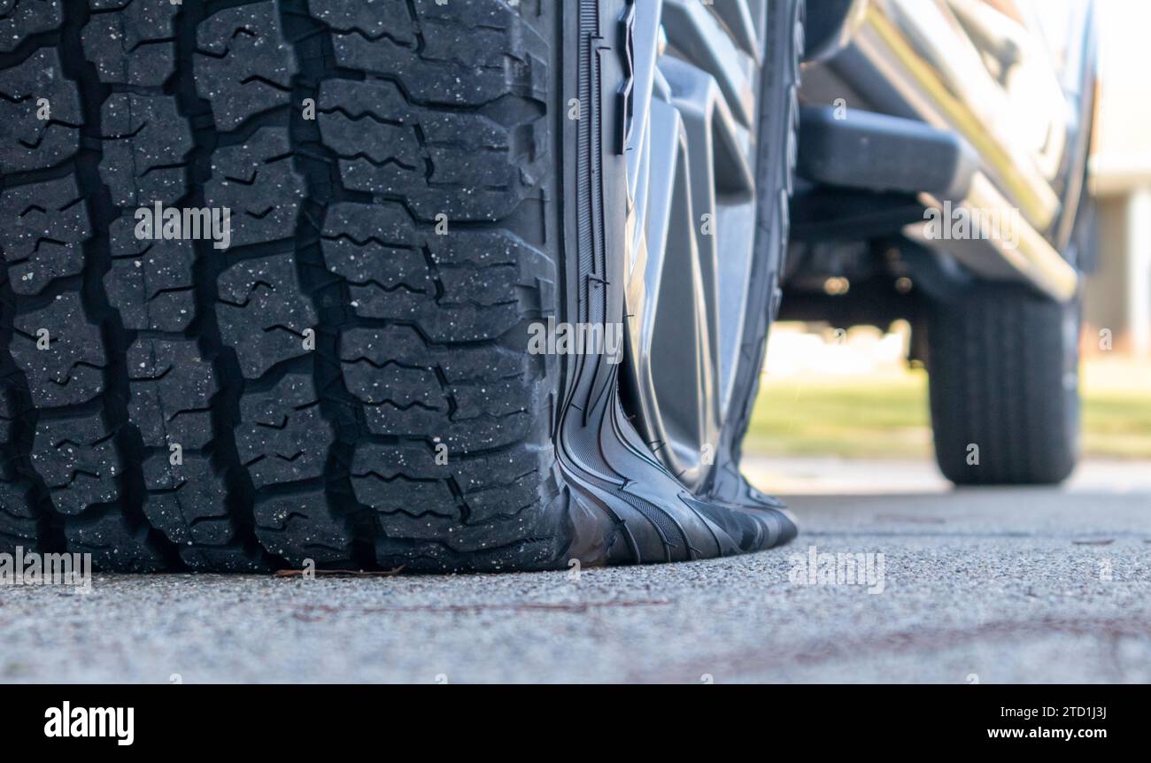 Flat tire on truck on cement, close up, low angle view Stock Photo