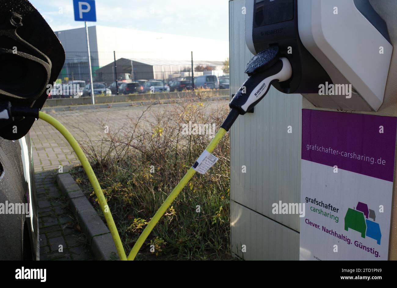 Neuenhaus, Germany- Nov 17 2023 Grafshafter carsharing. All electric car sharing car connected to a charging station. Stock Photo
