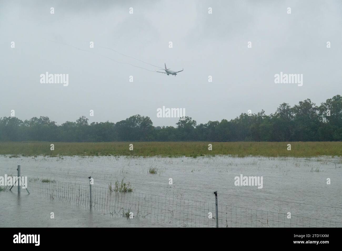 A Virgin Airlines jet flies over a flooded field in the northern ...