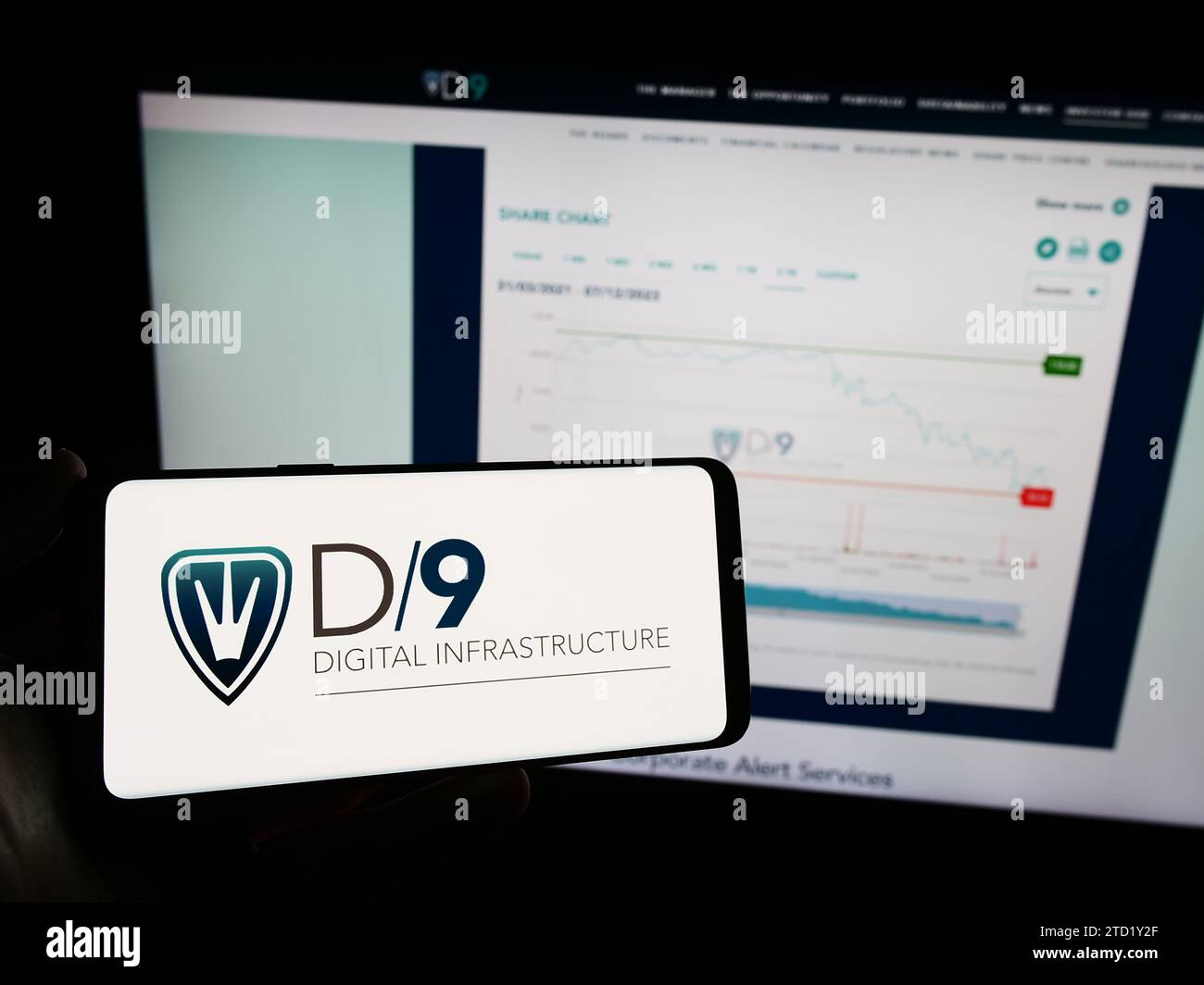 Person holding mobile phone with logo of British company Digital 9 Infrastructure plc (D9) in