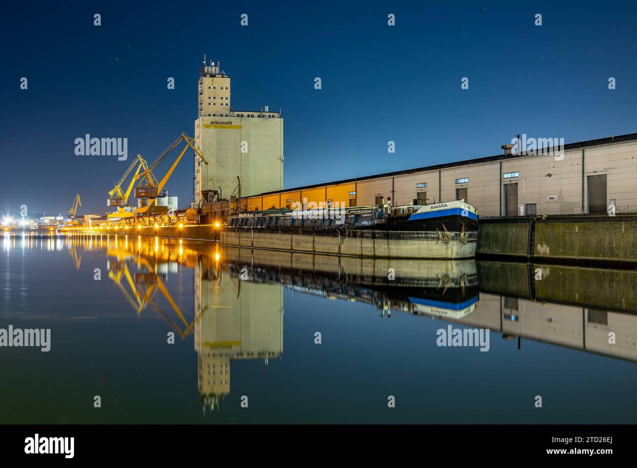 Nürnberger Hafenbecken bei Nacht mit vor Anker liegendem Frachtschiff. Das Hafensilo und das Schiff spiegeln sich vollkommen auf der ruhigen Wasseroberfläche. *** Nuremberg harbor basin at night with a cargo ship at anchor The harbor silo and the ship are completely reflected on the calm water surface 20230209-6V2A5179-HDR-Bearbeitet Stock Photo