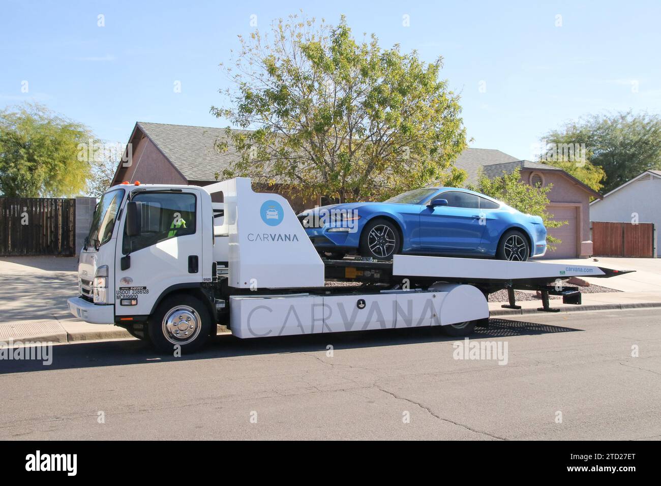 A Carvana representative moves a car sold onthespot onto a flatbed