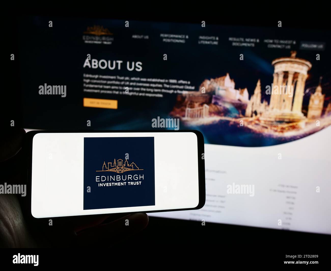 Person holding mobile phone with logo of British company The Edinburgh