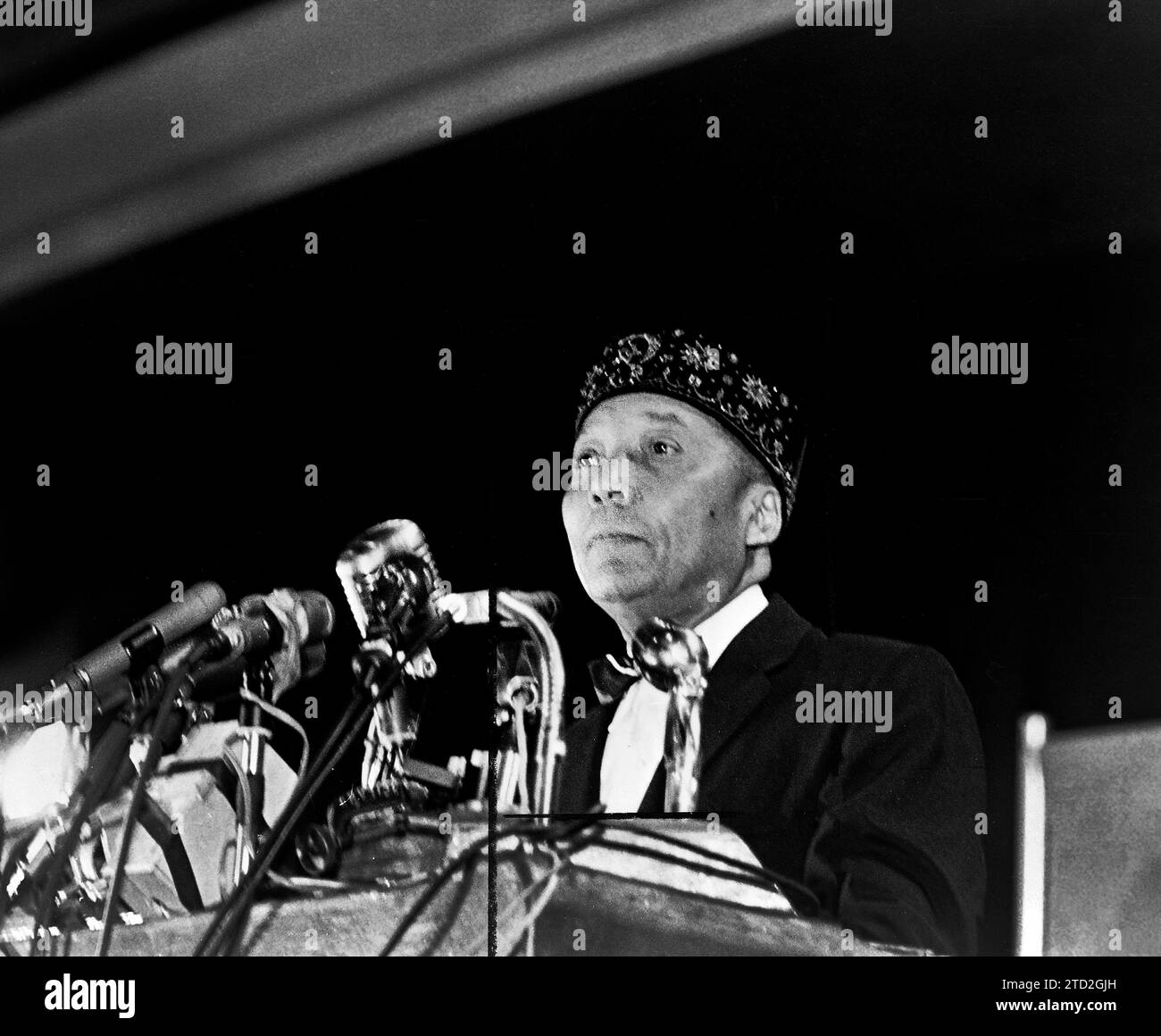 Elijah Muhammad standing behind microphones at podium, Stanley Wolfson