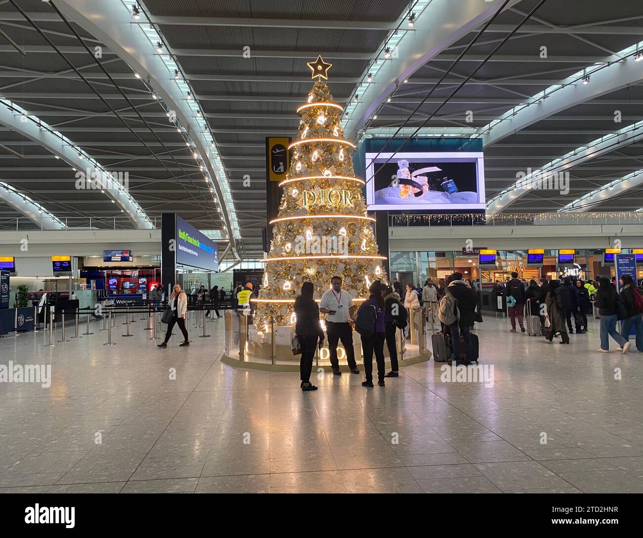 Heathrow has  partnered with Christian Dior for the first time. 22 ft Christmas trees in all terminals and 2 stunning golden trees in Terminal 5 .The Airport has become a magical destination in it's own right with a spectacular array of Christmas festivities .visits from Santa ,choir performances and live ballet to great arrivals .The ballet performance titled ( The Reunion ) is choreographed by award winning Ruth Brill .It will be performed in the arrivals section throughout the Christmas  Festive season Stock Photo
