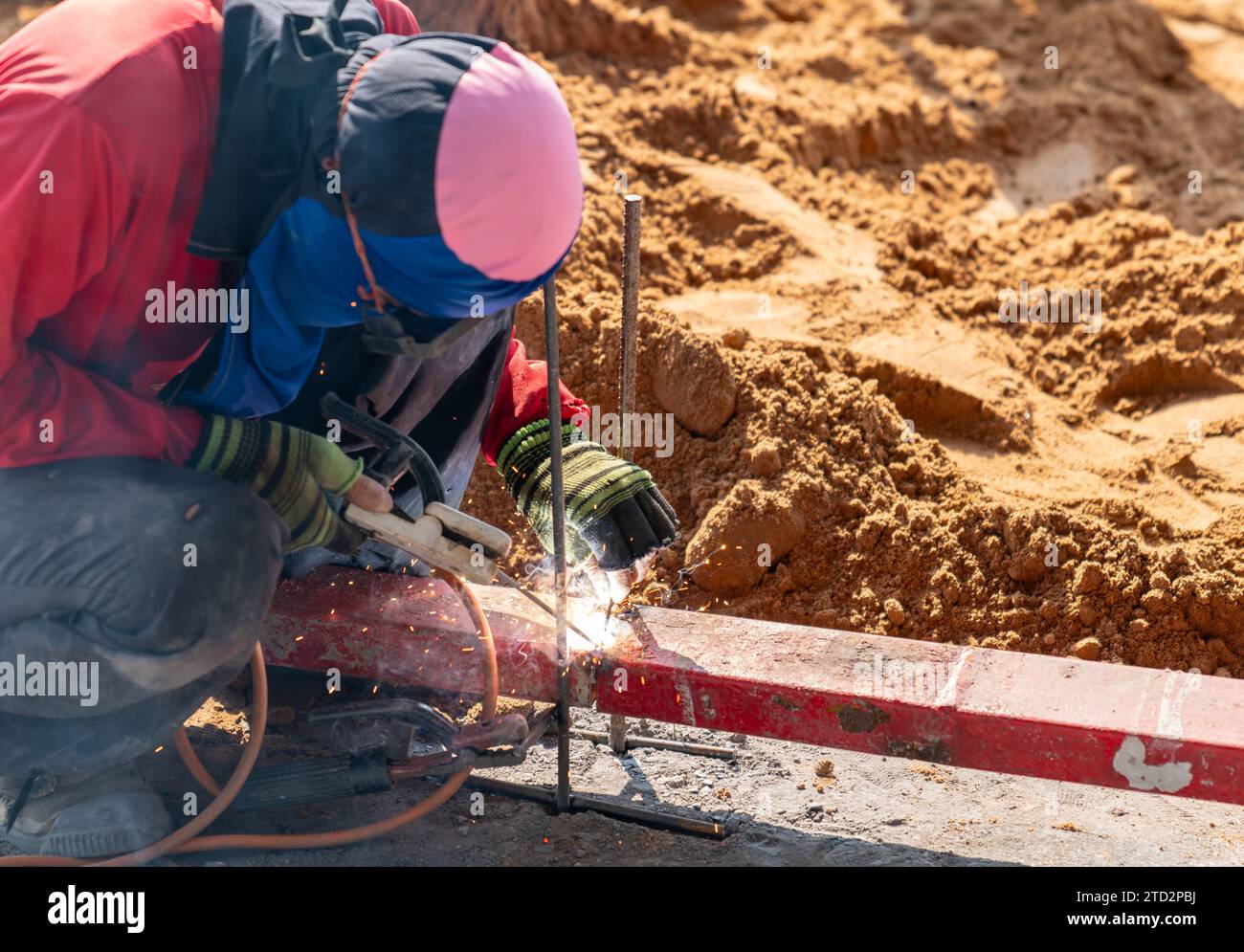 Construction worker welding metal rebar for the pouring of concrete