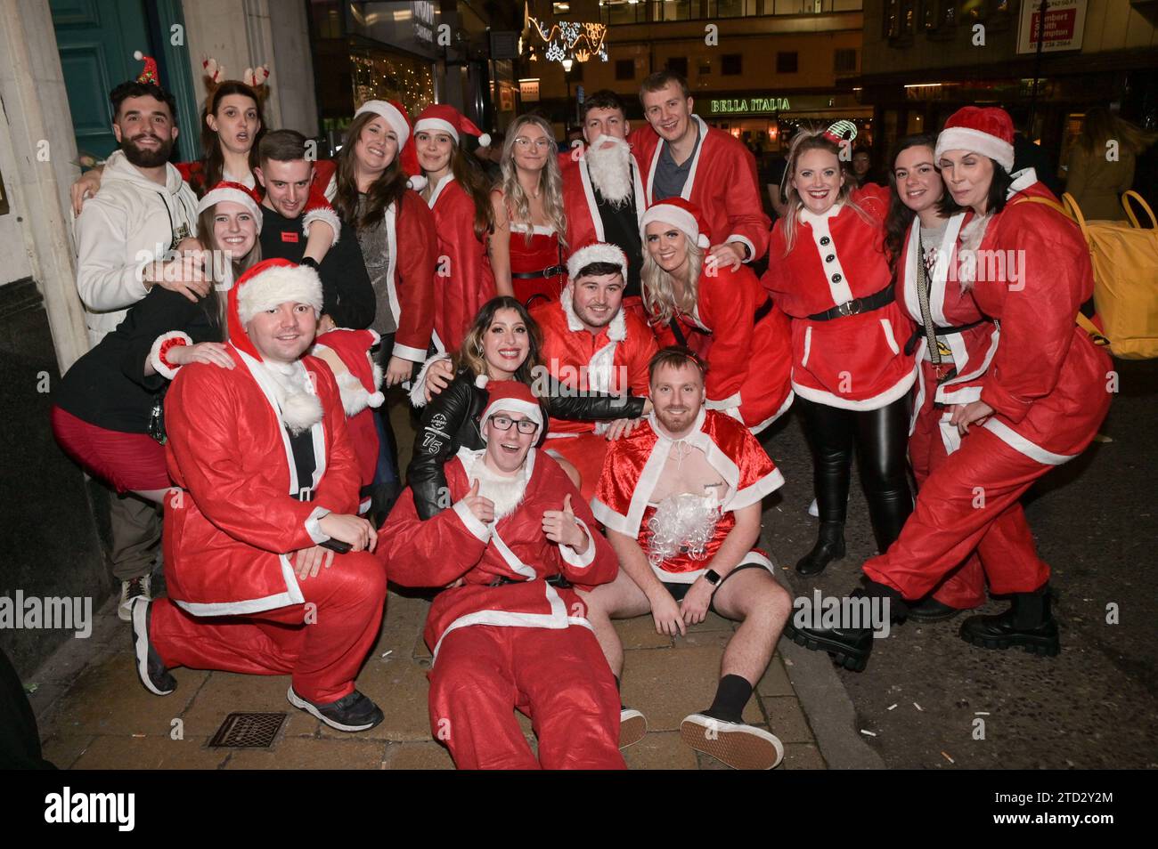 New Street, Birmingham 15th December 2023 - Revellers hit Birmingham’s infamous nightclub strip on Friday 15th December evening as they enjoyed the second-to-last Friday before Christmas. Several partygoers wore Christmas outfits and a work party full of Santas posed for a group photo before making their way to another pub. Friends were carrying each other along the Broad Street nightlife area as the evening turned into morning. Others were seen in smart wear after attending city centre festive galas. Plenty of people showed off their Christmas Jumpers as they enjoyed mild temperatures. The ni Stock Photo