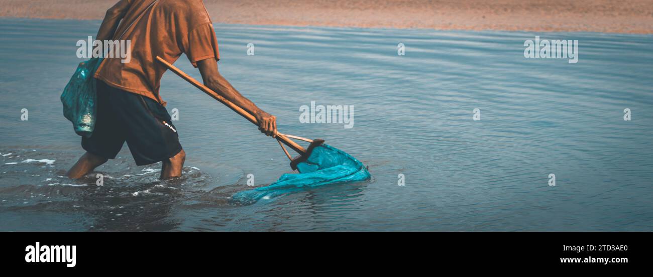 People catch fish that float on the surface of the water because they are poisoned by the roots of the tuba plant or Derris. environmental problems Stock Photo