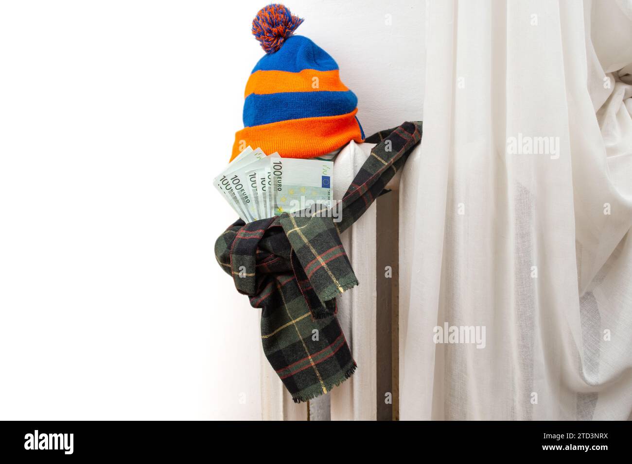 Vintage metal heating radiator with winter hat and scarf stuffed with euro banknotes Stock Photo