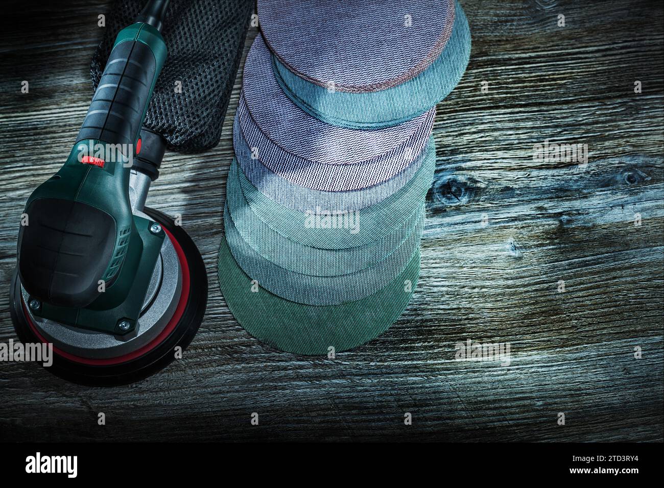 Electric orbit wood sander with sanding discs on dark vintage wooden background Stock Photo