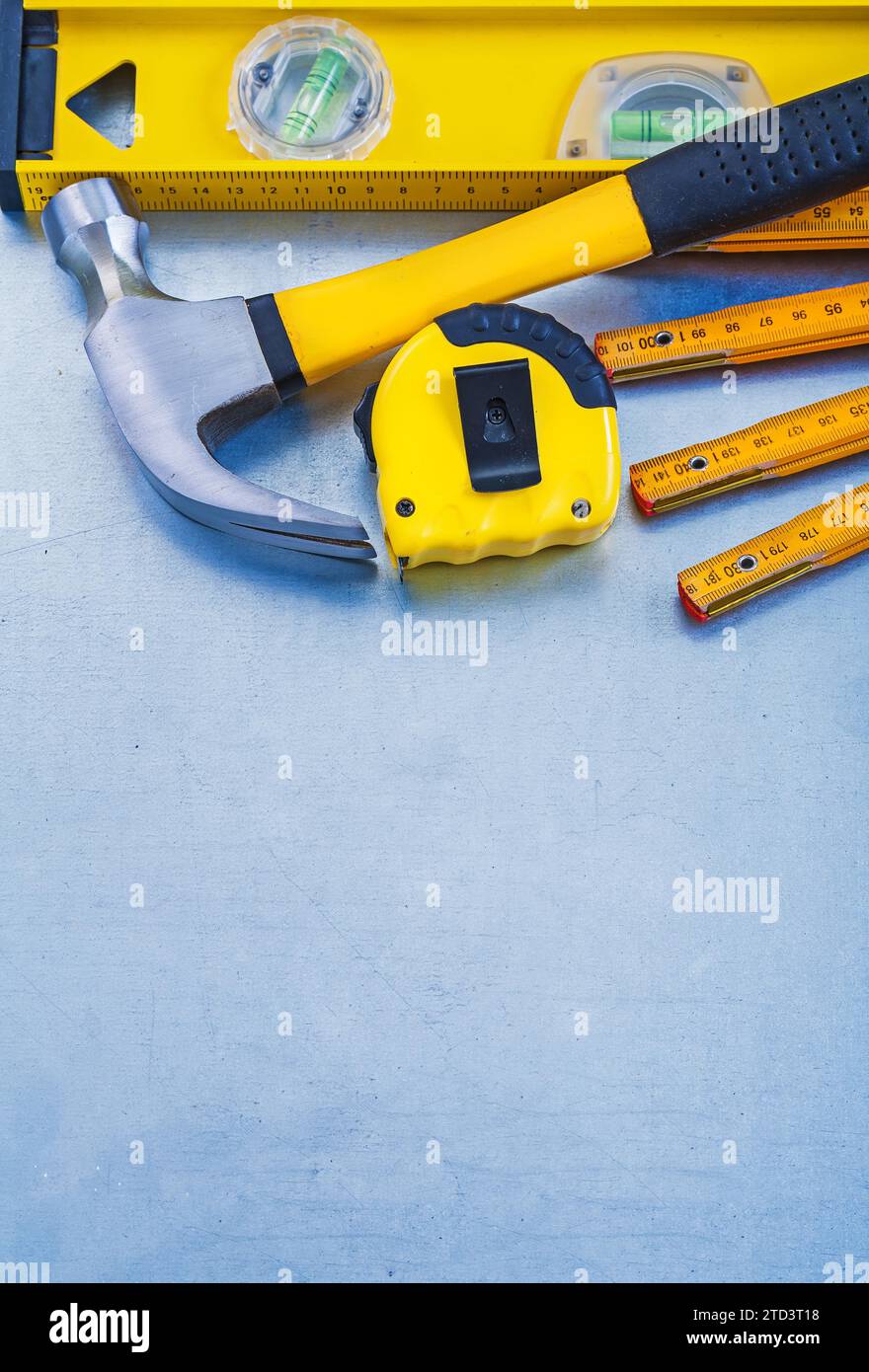 Construction level tape line claw hammer wooden meter on metallic background copy space image