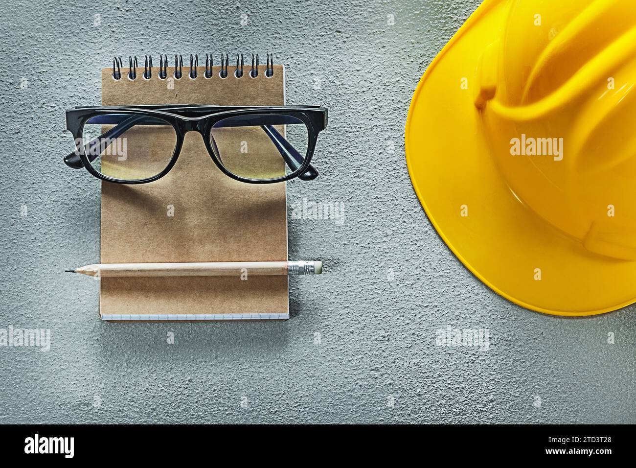 Hard hat glasses notebook pencil on concrete background Stock Photo Alamy