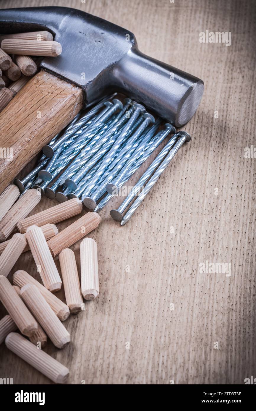Wooden dowels construction nails hammer vertical version Stock Photo