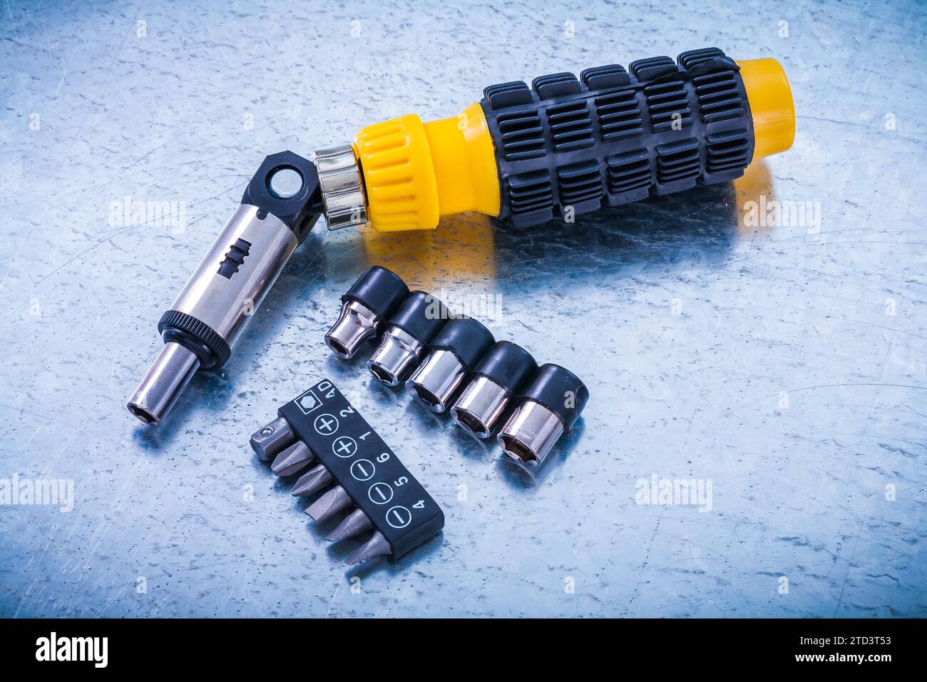 Reversible screwdriver screw bits and torxes on metallic background