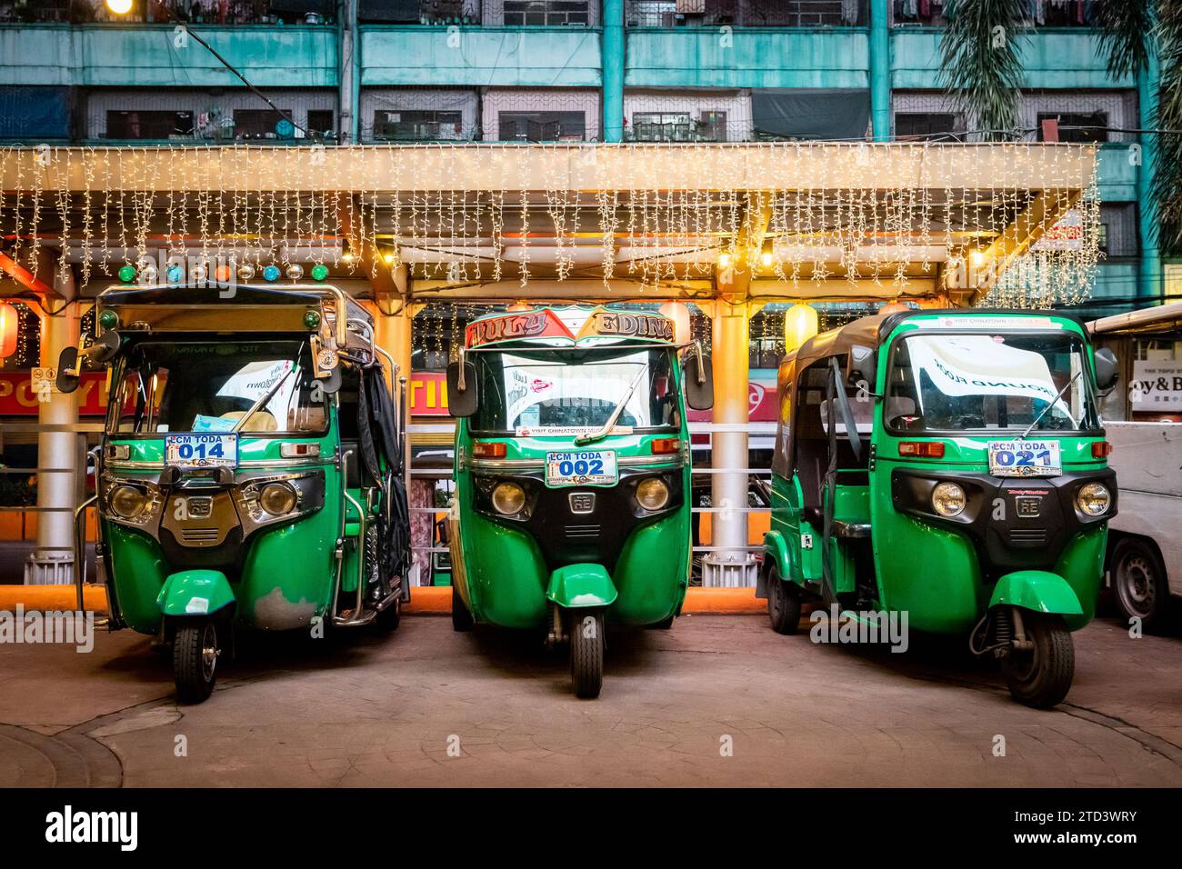 three-stylish-green-tuk-tuks-lined-up-outside-a-shopping-centre-in-the