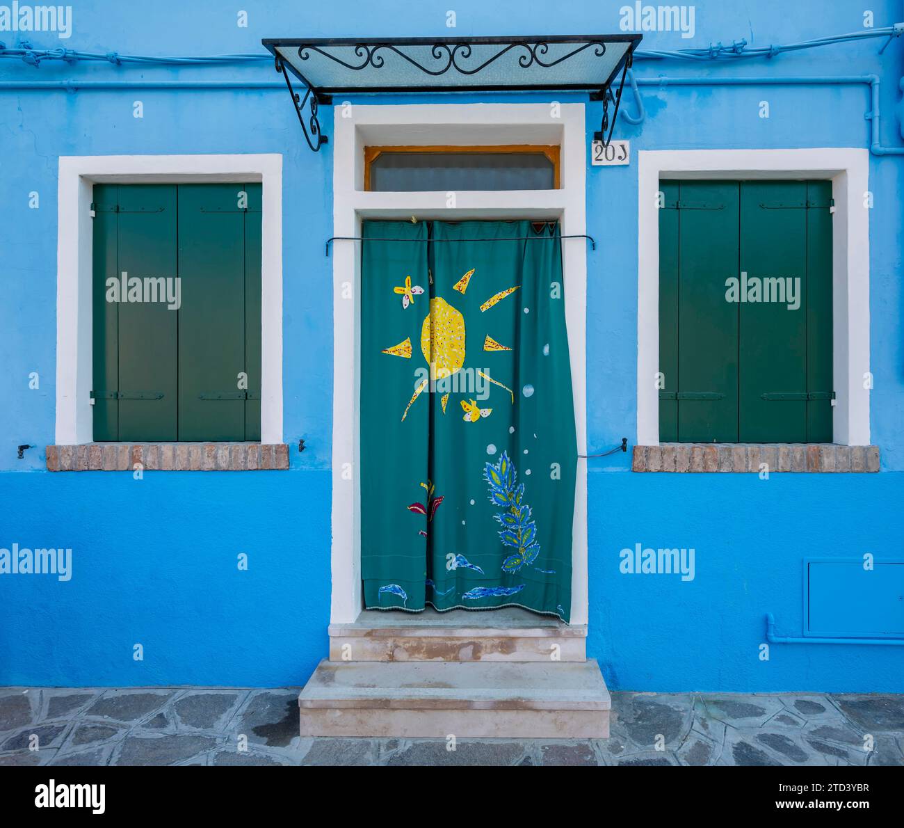 Blue house facade with entrance door with green painted curtain and ...