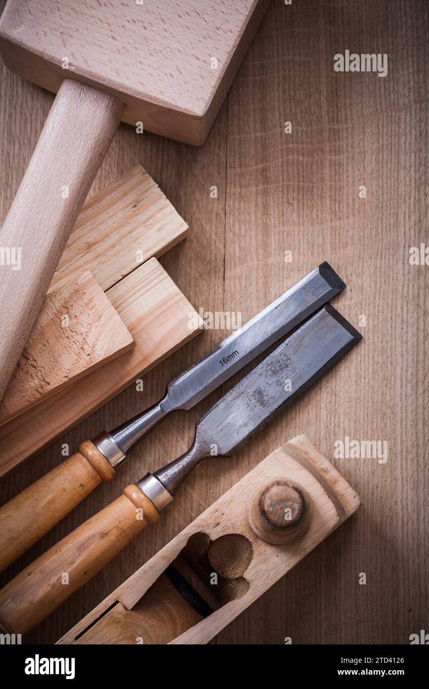 Hand lump hammer Plough metal fixed chisel and wooden bolt on wooden plate Construction concept Stock Photo