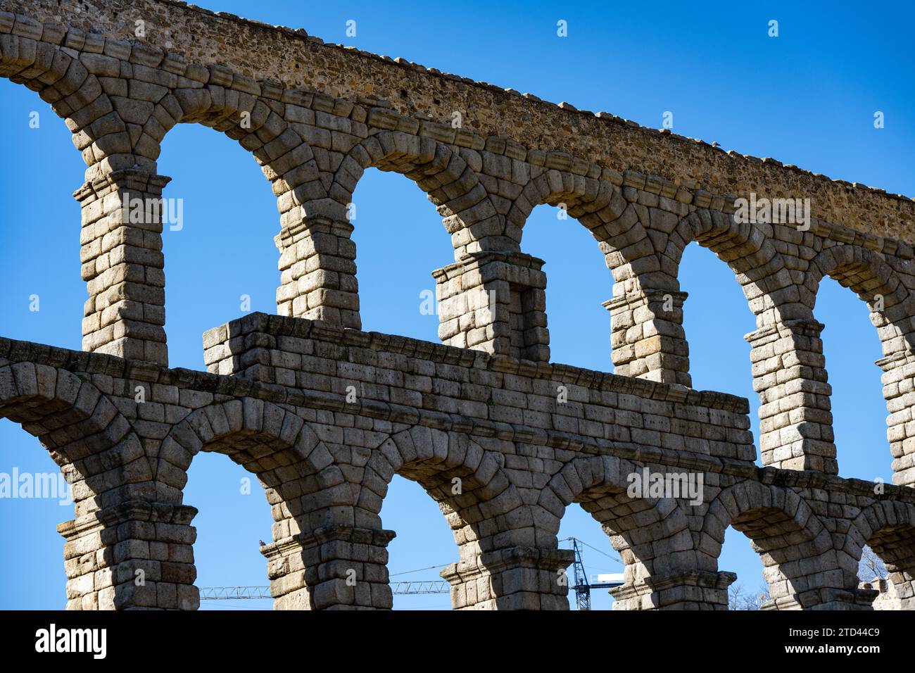 Ancient Roman aqueduct of Segovia with arches in perspective, clear ...