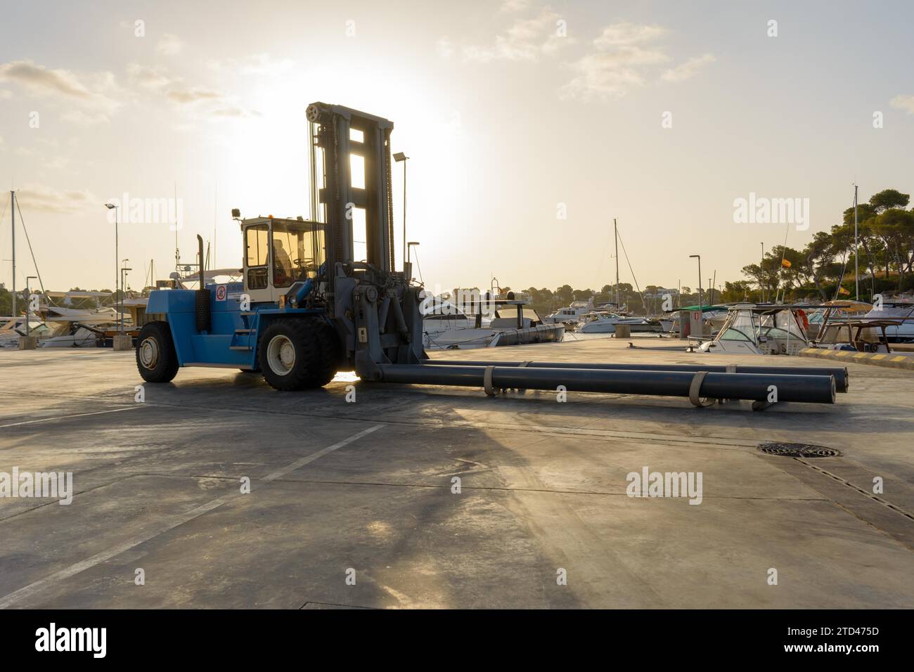 Forklift lowers a boat into the water at a marina Stock Photo
