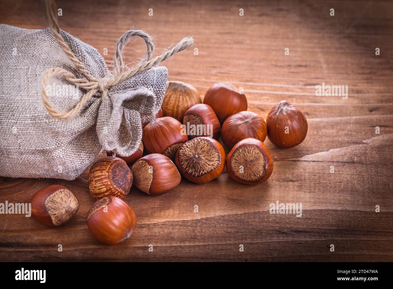 Hazelnuts and sack on vintage wooden board Food and drink concept Stock Photo