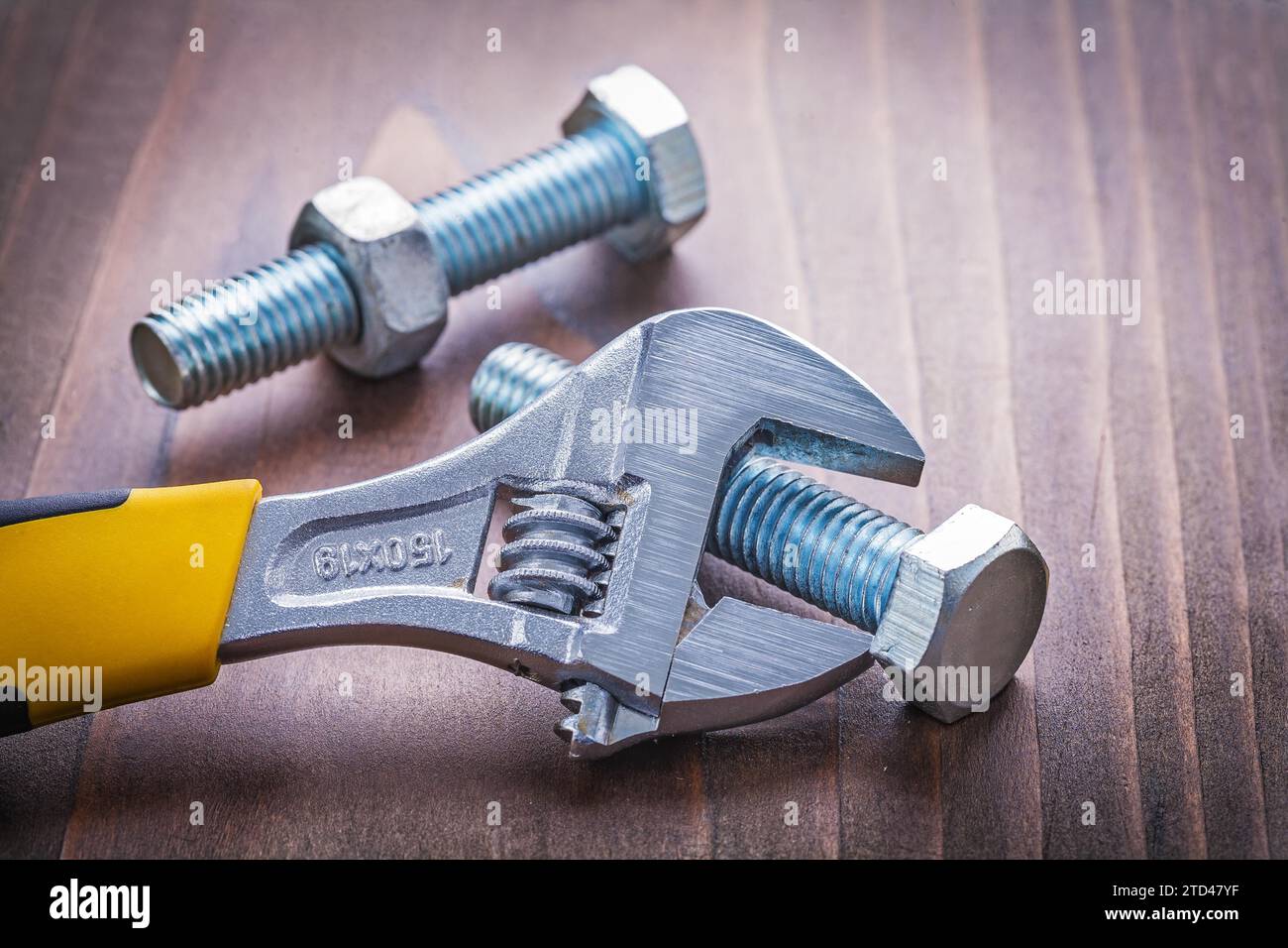 Adjustable spanner and bolt on vintage wooden board Construction