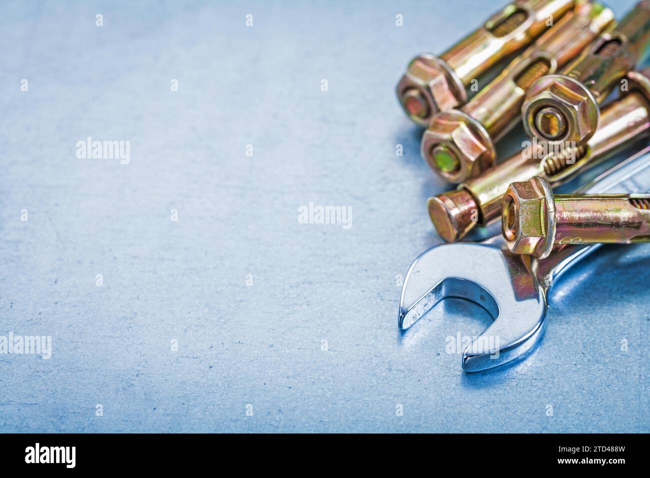 Metal anchor bolts for concrete walls and spanners on a metallic
