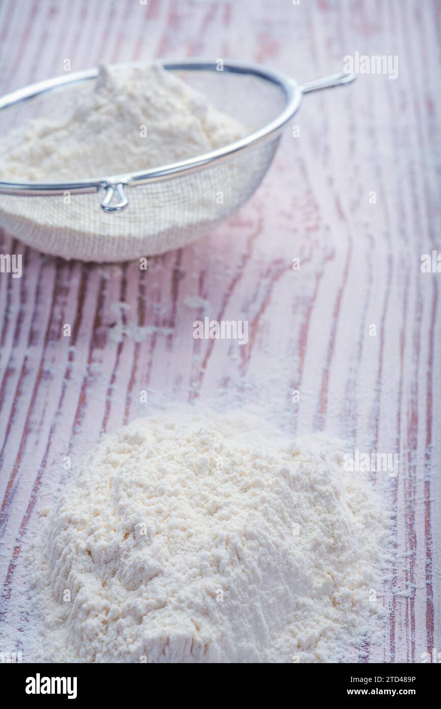 Flour in sieve on vintage wooden board Food and drink concept Stock Photo
