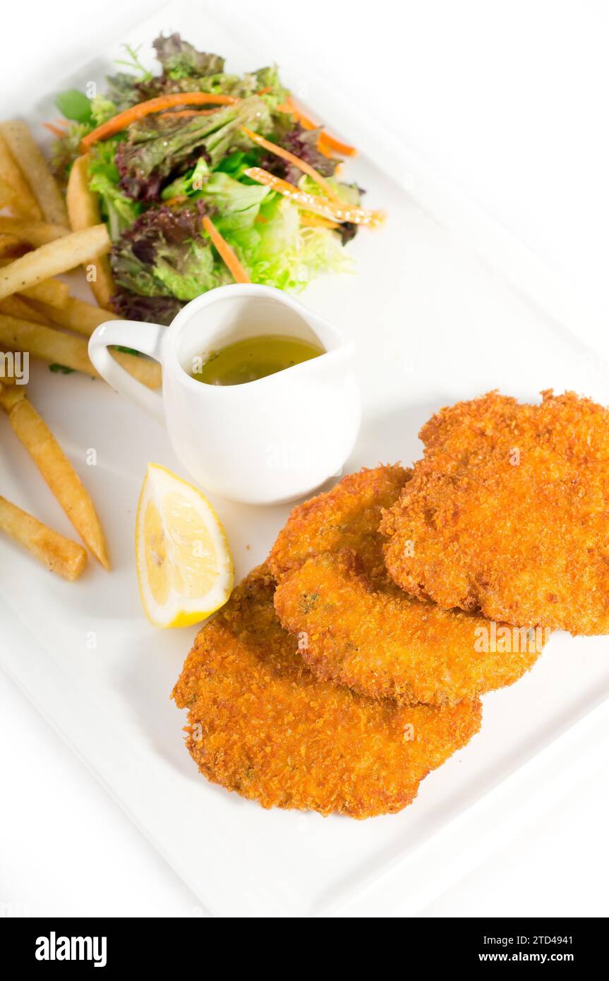 Classic breaded Milanese veal cutlets with french fries and vegetables