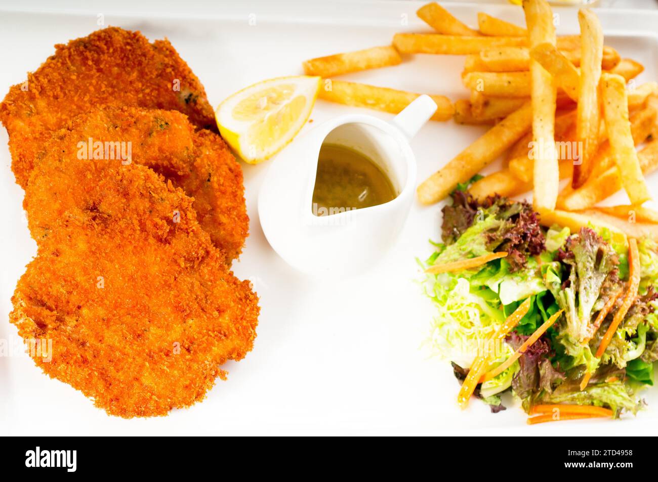 Classic breaded Milanese veal cutlets with french fries and vegetables